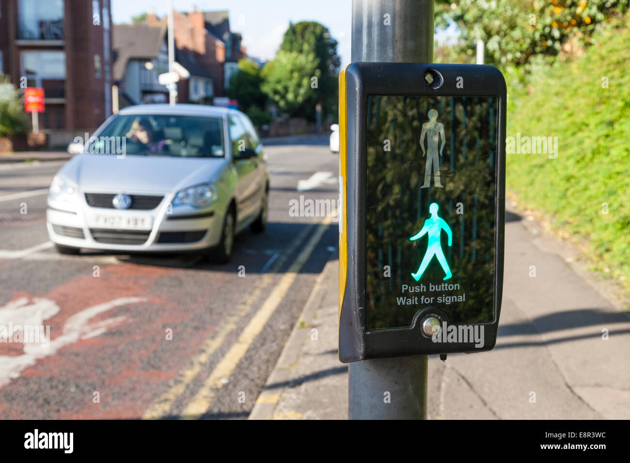 Car waiting at a puffin pedestrian crossing with the control showing an illuminated green man sign, Nottinghamshire, England, UK Stock Photo