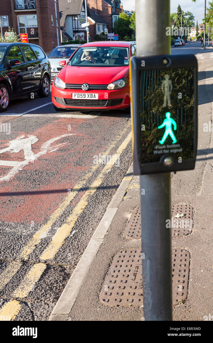 Cars waiting at a puffin pedestrian crossing with the control showing the green man sign lit, Nottinghamshire, England, UK Stock Photo