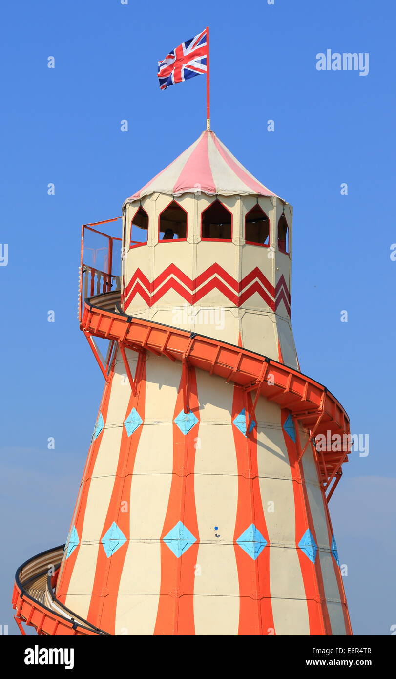 A helter skelter fairground ride, painted in traditional style, with a British flag on top. Stock Photo
