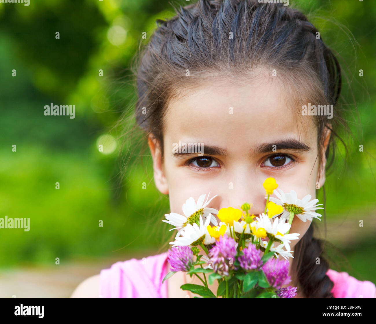 Close up portrait of little smiling girl with spring flowers bouquet ...