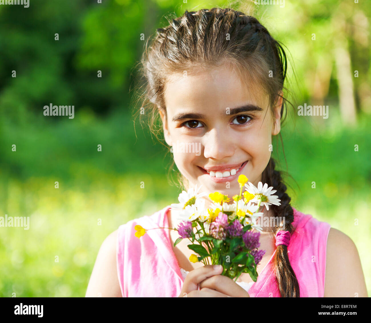 Close up portrait of little smiling girl with spring flowers bouquet ...
