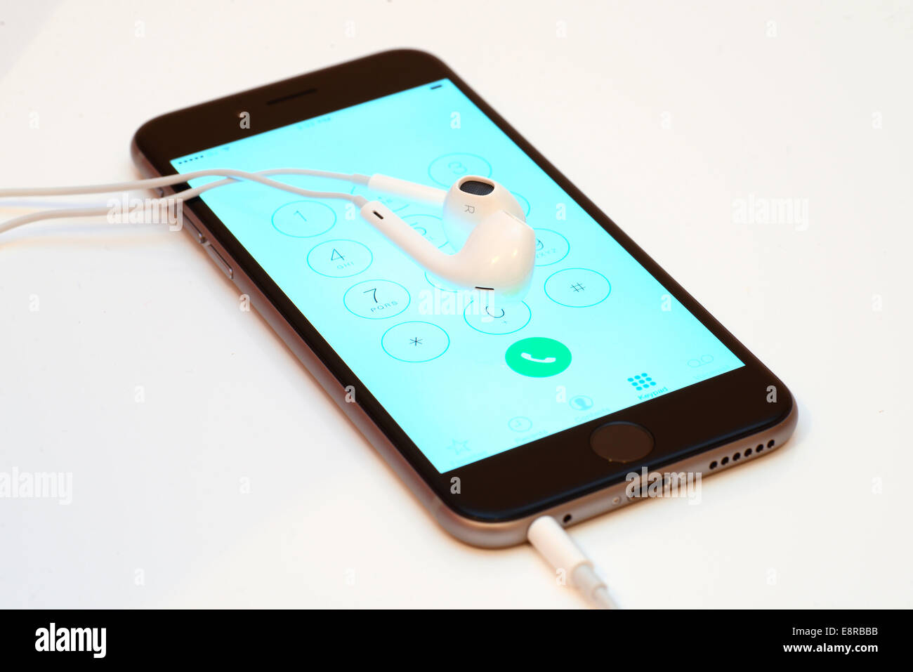 Apple iPhone 6 on white background with earbuds and phone application open Stock Photo