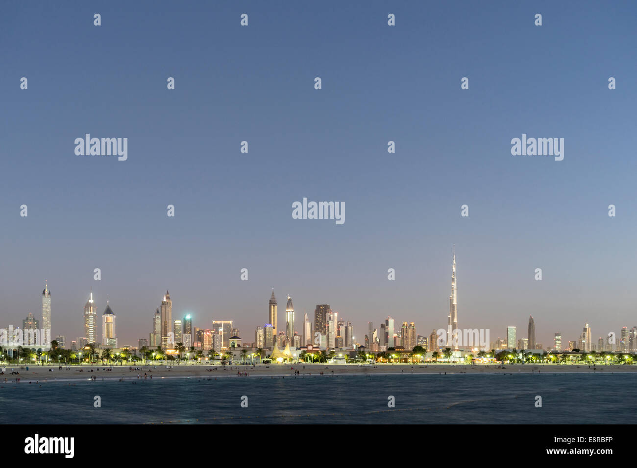 Skyline at dusk of skyscrapers and Burj Khalifa along Sheikh Zayed Road from Jumeira Open Beach in Dubai United Arab Emirates Stock Photo