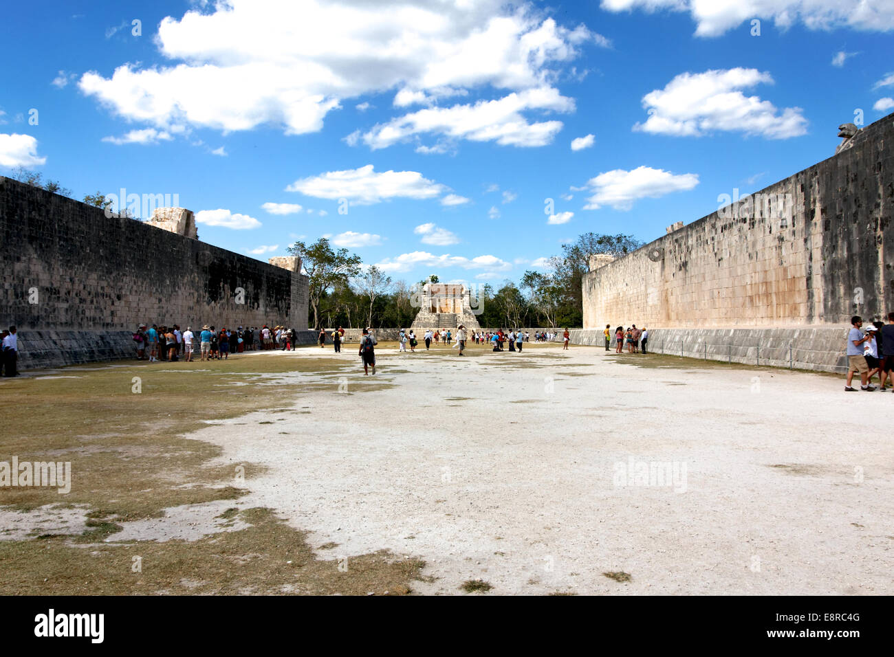 Tourists roam the ancient Mayan ball game Court of the Juego de Pelota ruins at Chicen Itza, Yucatan, Mexico in March 2012. Stock Photo