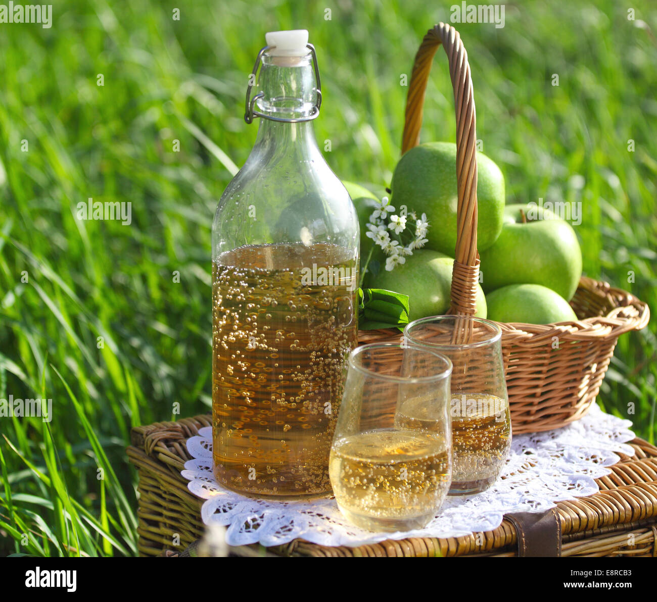 Apple drink and basket with green apples outdoors Stock Photo