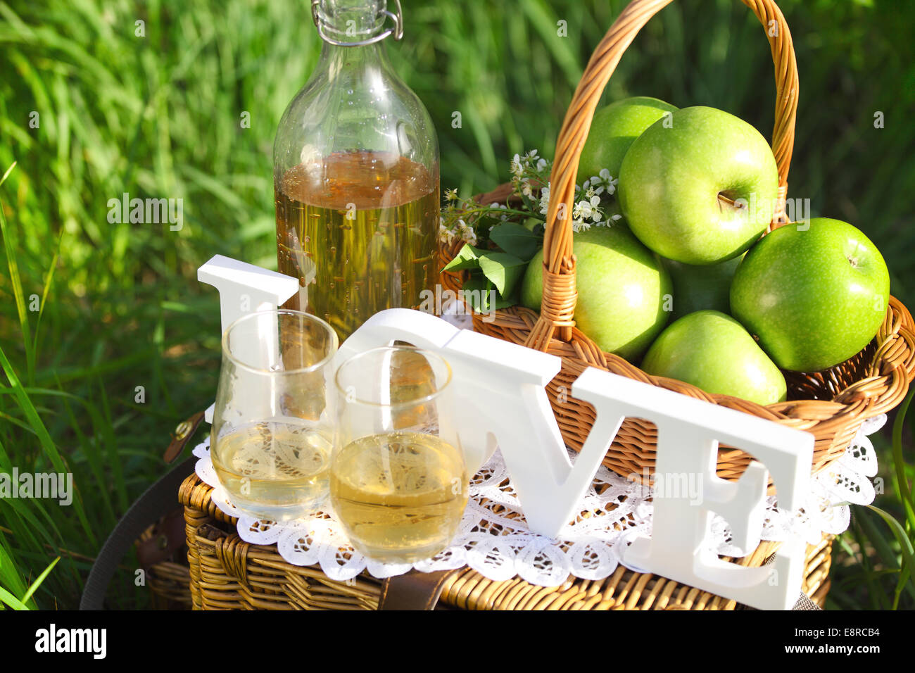 Apple drink and basket with green apples outdoors Stock Photo
