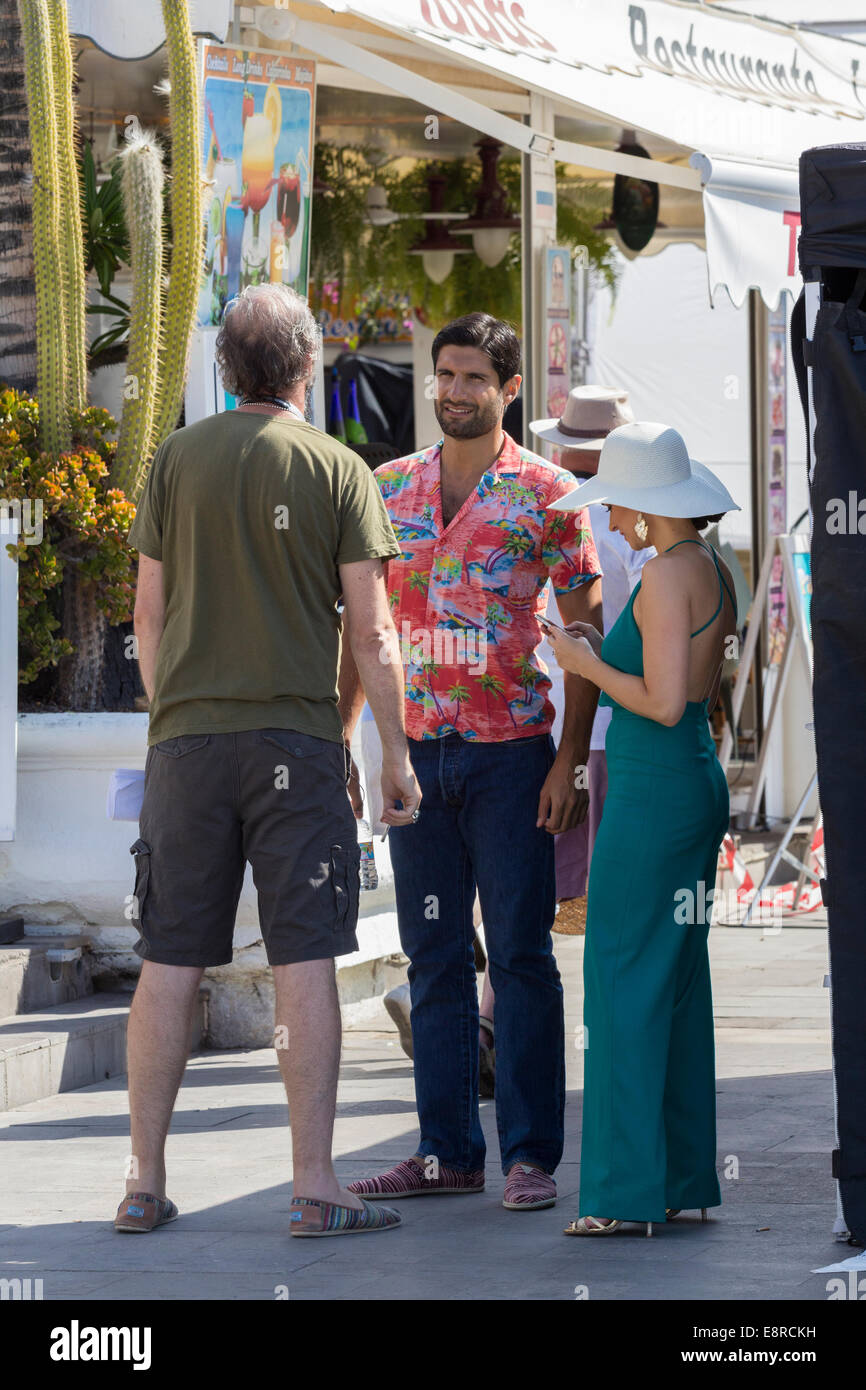 Puerto de Mogan, Gran Canaria, Canary Islands. 13th Oct, 2014.  BAFTA winning actor Kayvan Novak (centre) and we belive Emma Pierson (right) on the set  on the First day of filming of a new BBC commissioned 6 part comedy, 'Woody,' starring Bradley Walsh and Kayvan Novak. Set on a fictional Spanish island, filming is taking place in the marina at Puerto de Mogan on Gran Canaria in The Canary Islands. The series has been created by Neil Webster and Charlie Skelton and produced/directed by Neil Webster and Ben Palmer of Happy Tramp Productions for BBC One. Credit:  ALANDAWSONPHOTOGRAPHY/Alamy Liv Stock Photo