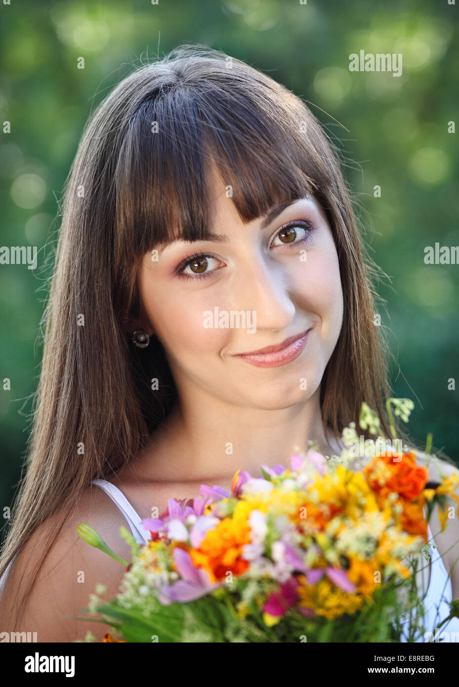 Beautiful young girl with flowers in summer park Stock Photo - Alamy