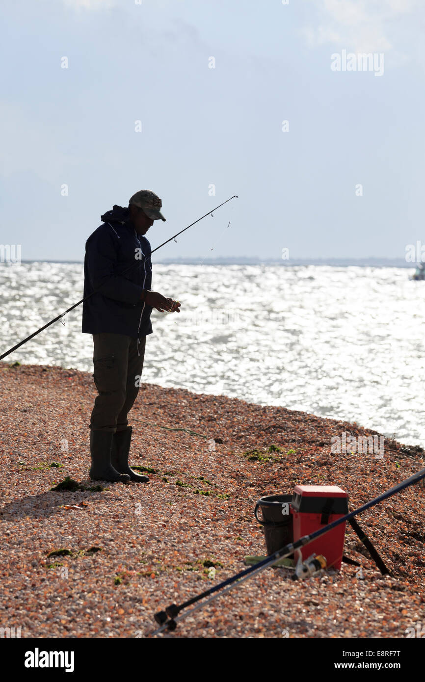Semi silhouette of beach fisherman baiting a hook. Stock Photo