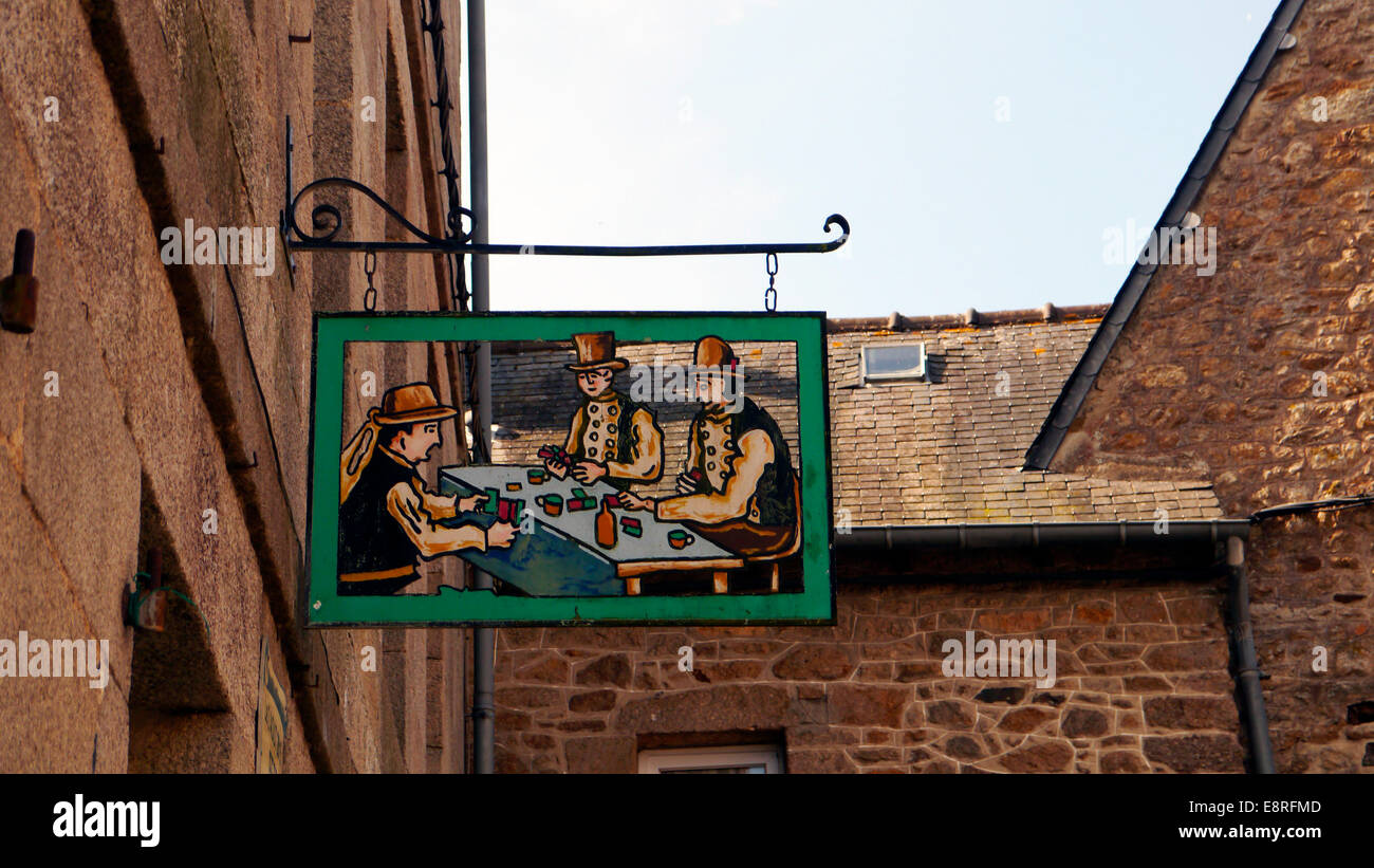 a pub bar card playing signpost in the historic picturesque medieval town of Moncontour, Brittany,  Northern France. Stock Photo