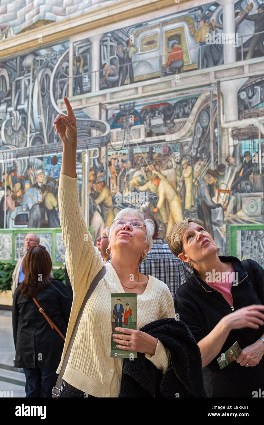 Detroit, Michigan - Visitors to the Detroit Institute of Arts study Diego Rivera's 'Detroit Industry' murals. Stock Photo