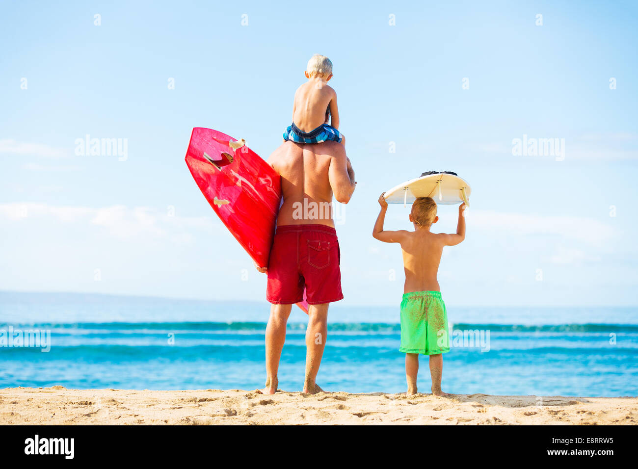 Father and Young Sons Going Surfing at the Beach, Looking out at the Ocean Checking the Waves Stock Photo