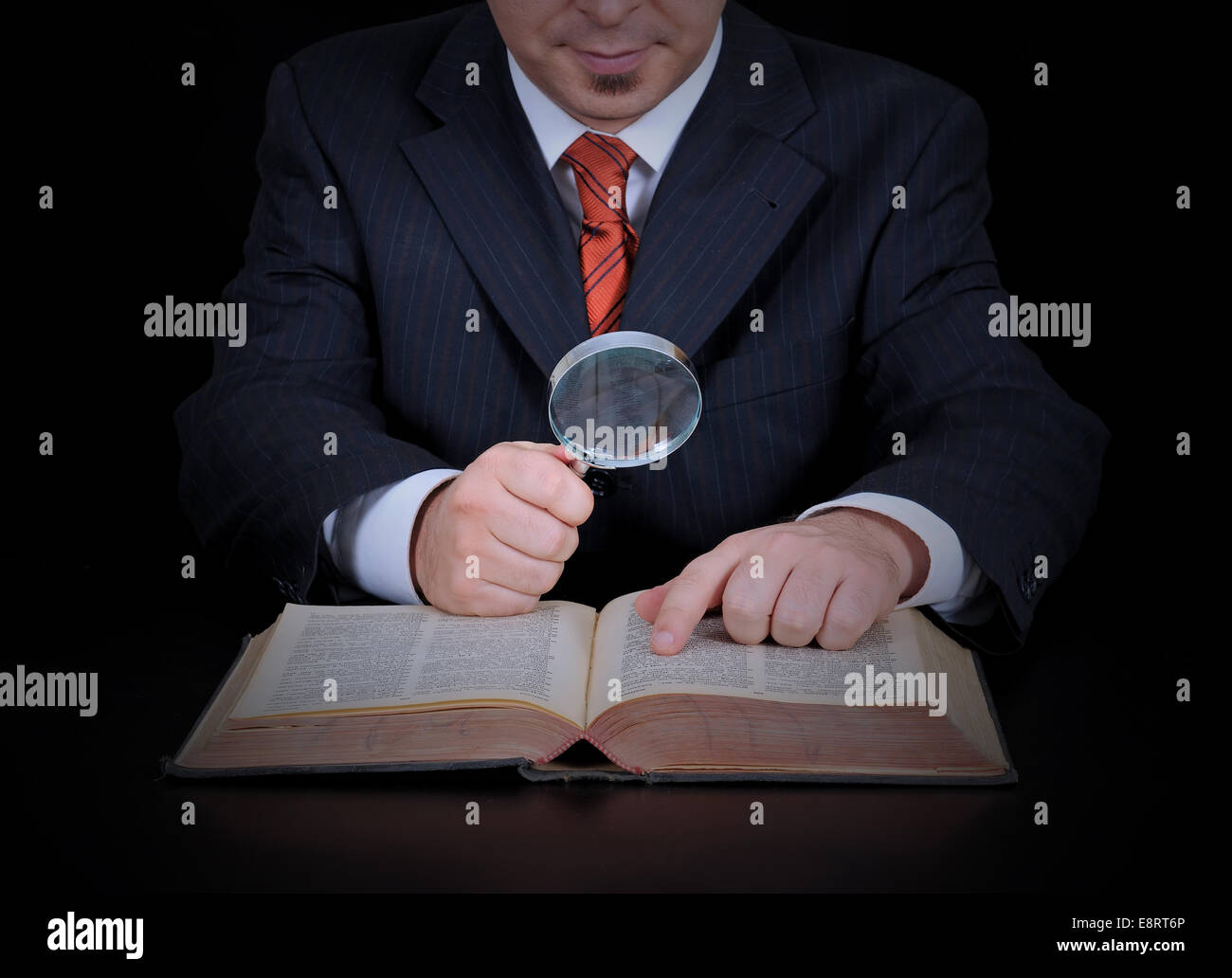 Mans Hand Examining An Old Stamp Book With Magnifying Glass Stock