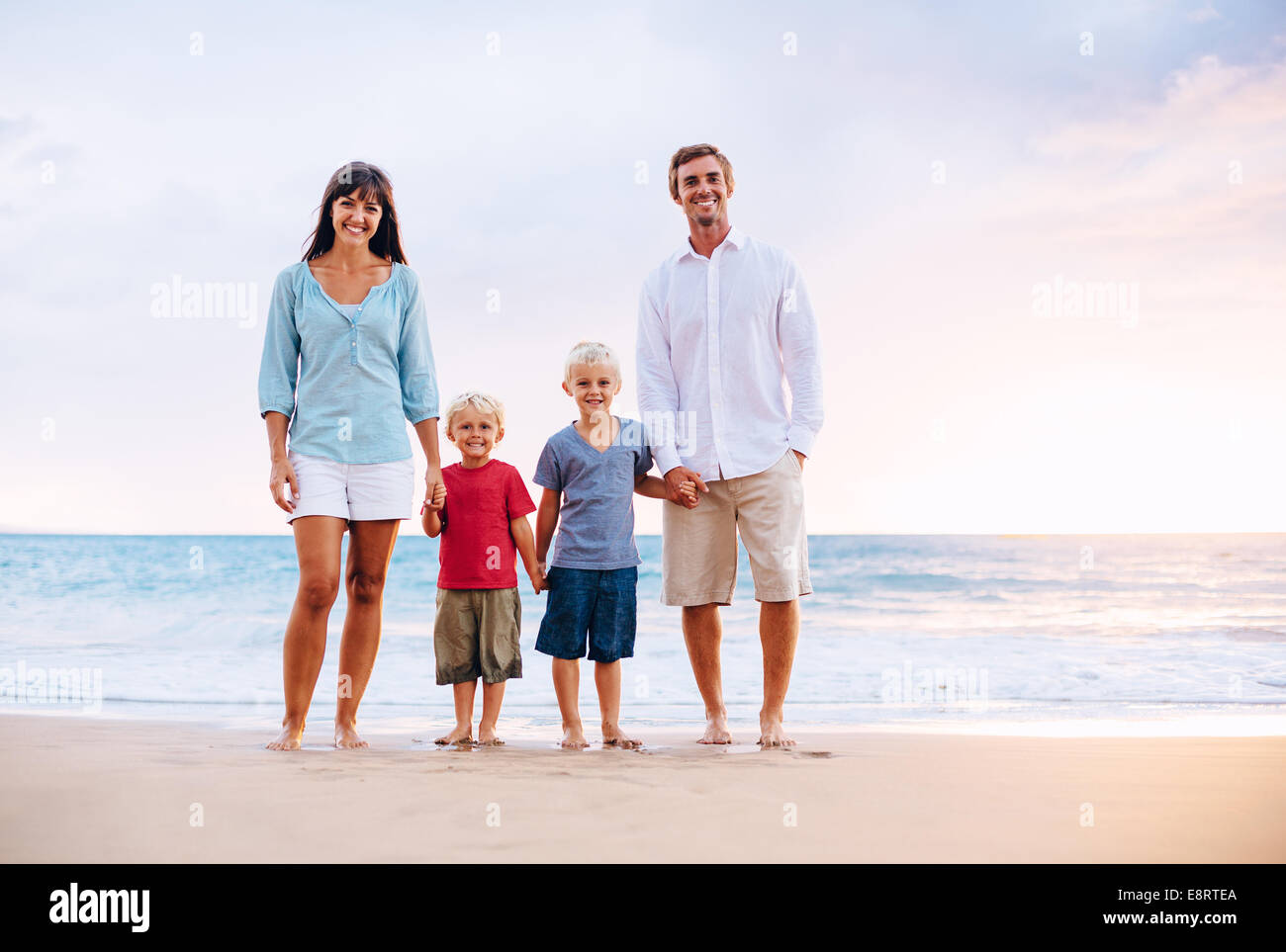 Happy Family of Four on the Beach at Sunset Stock Photo - Alamy