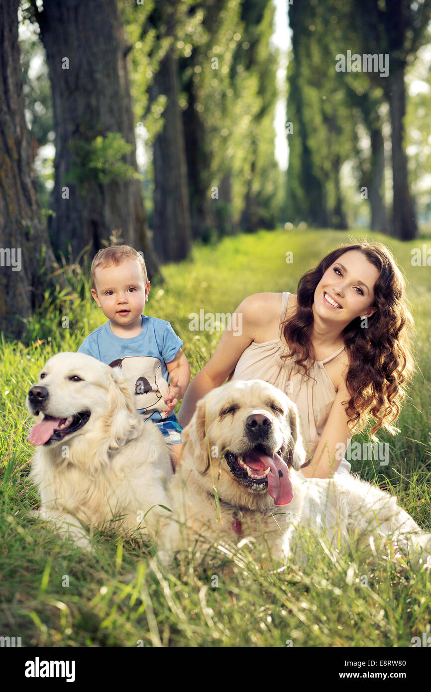 Mother and baby playing with dogs Stock Photo