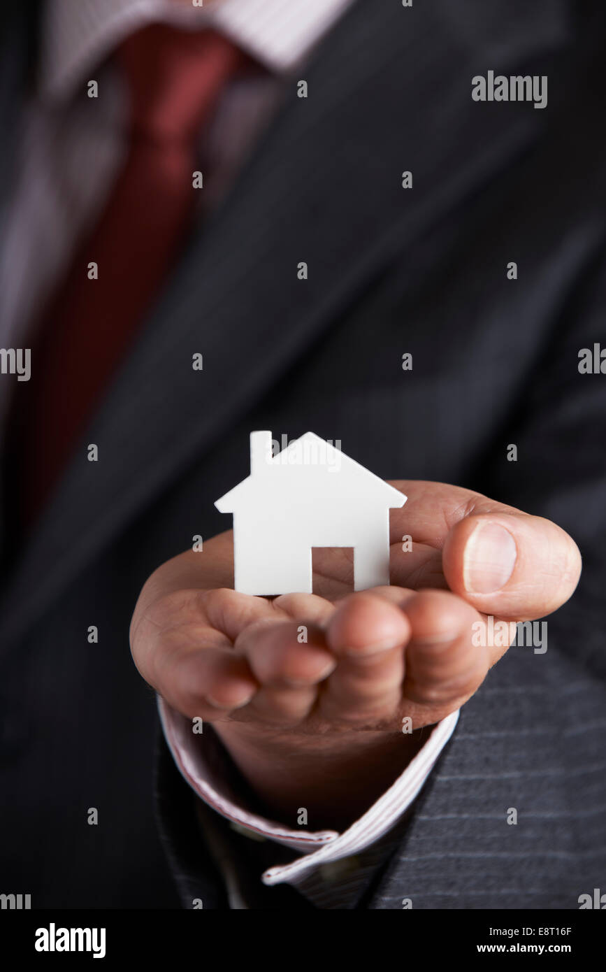 Businessman Holding Model House In Palm Of Hand Stock Photo - Alamy