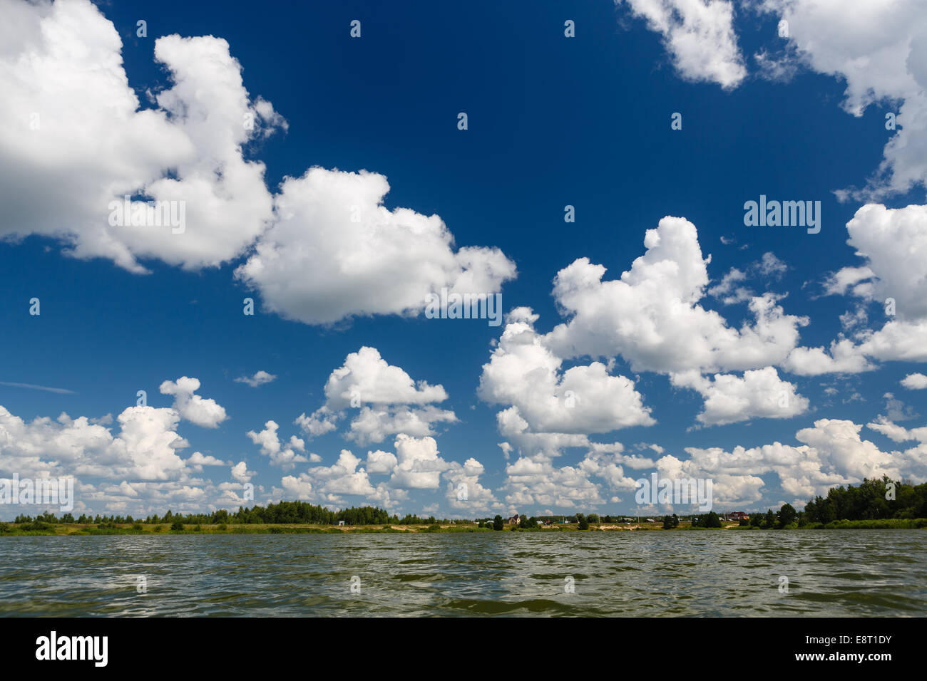 Cumulus clouds in blue sky over the lake Stock Photo - Alamy