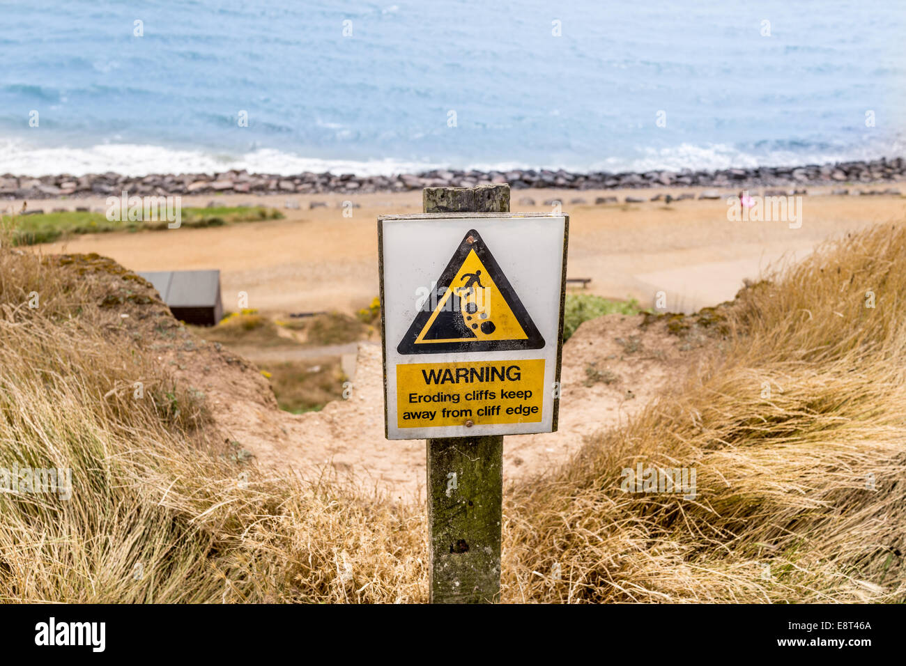 Caution falling cliffs sign on the cliff edge at Highcliffe overlooking the sea Stock Photo