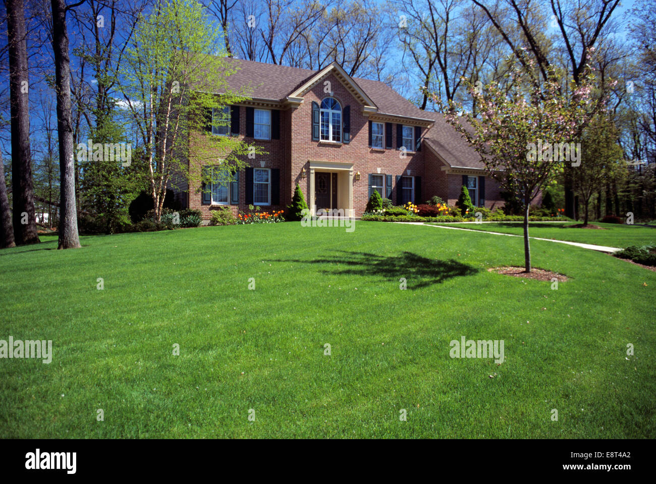 Two story brick house landscaped lawn hires stock photography and
