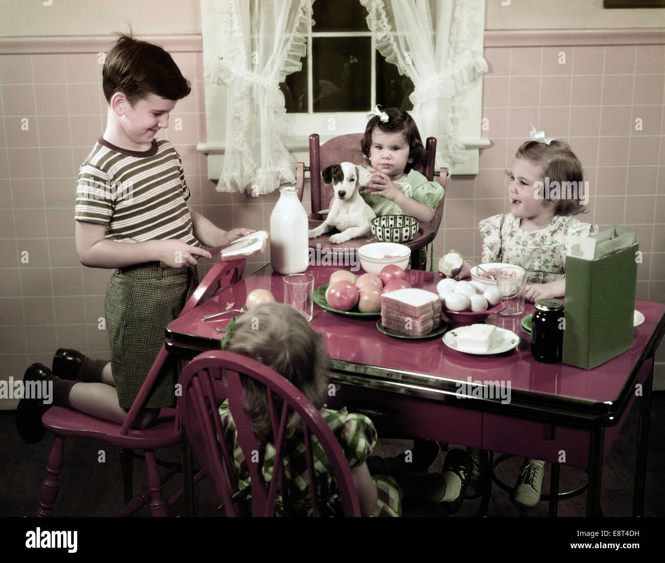 1940s 1950s BOY MAKING PEANUT BUTTER SANDWICH IN KITCHEN THREE GIRLS