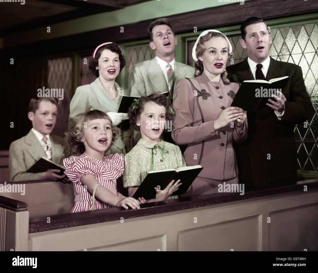 1950s TWO FAMILIES PARENTS CHILDREN IN CHURCH PEWS SINGING FROM Stock ...