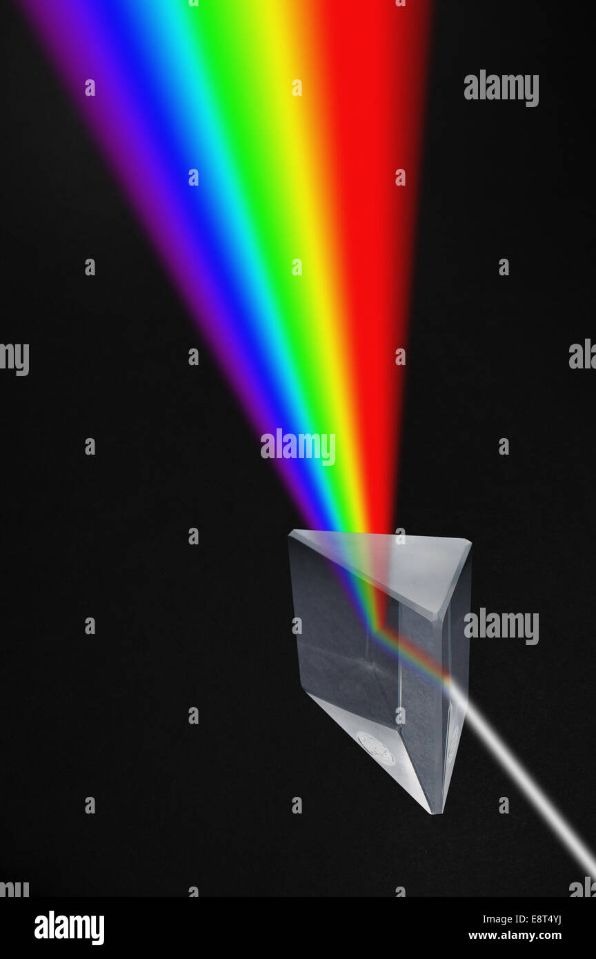 Light passing through a triangular highly polished prism broken up into colors of spectrum rainbow Stock Photo