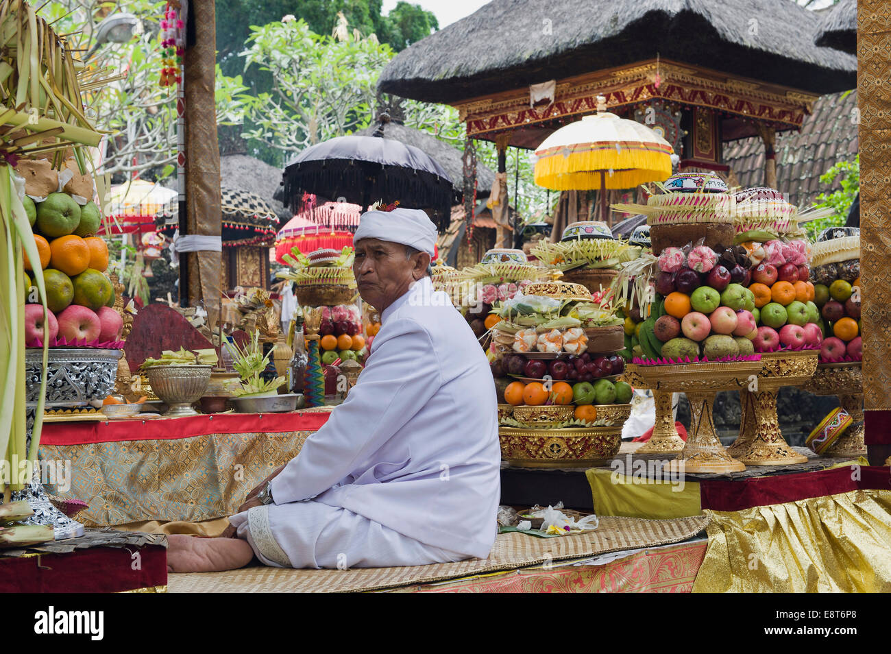 A Hindu priest amidst sacrificial offerings at a temple ceremony, Pura Desa Temple, Ubud, Bali, Indonesia Stock Photo