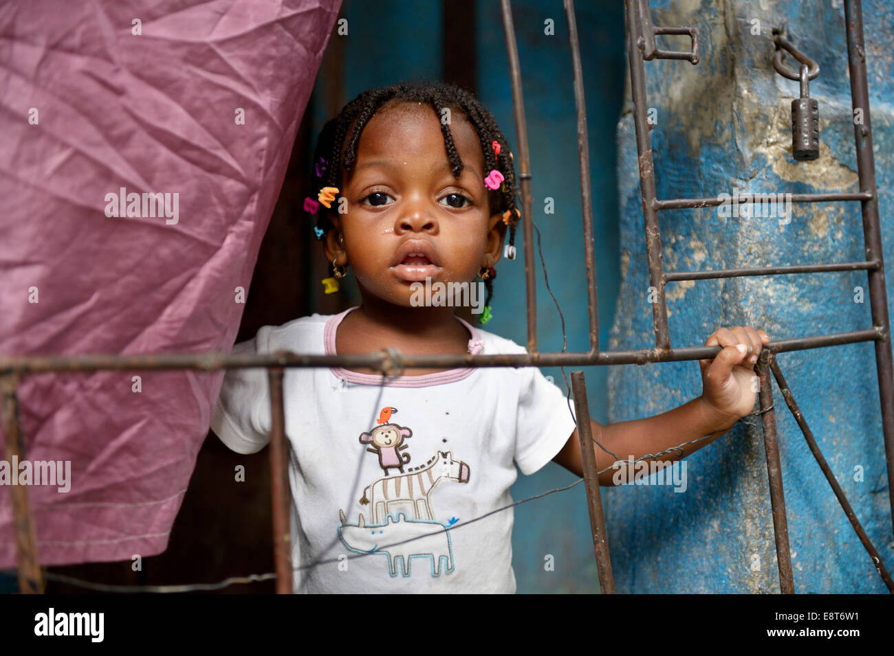 Girl behind a fence in a doorway, Fort National slum, Port-au-Prince, Haiti Stock Photo
