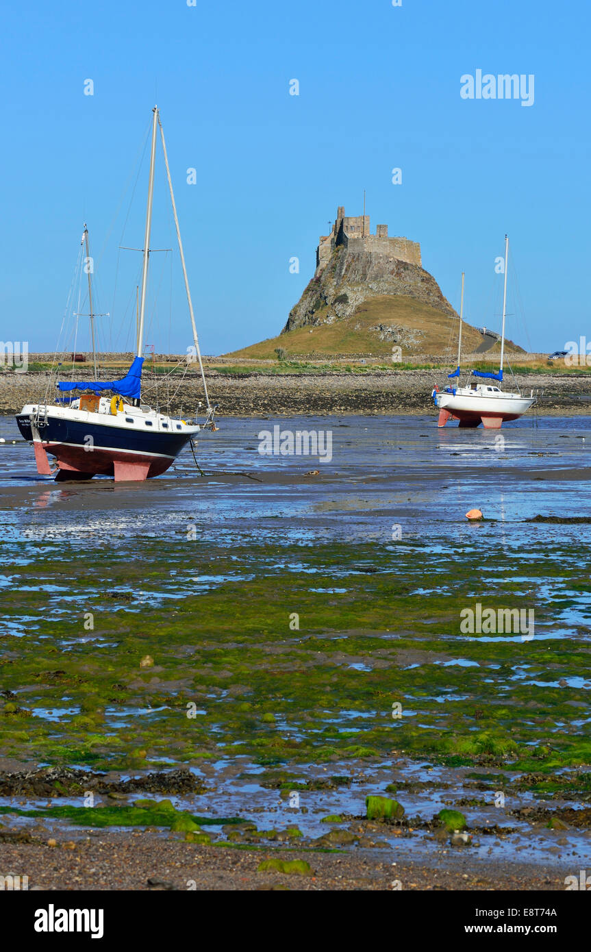 Sailing boats at low tide in the bay off Lindisfarne Castle, Lindisfarne, Northumbria, England, United Kingdom Stock Photo
