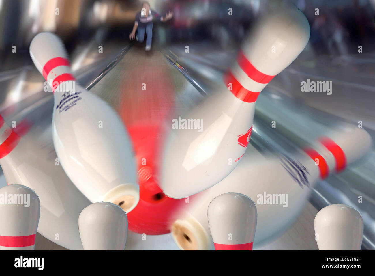 Bowling pins being hit by a red bowling ball Stock Photo