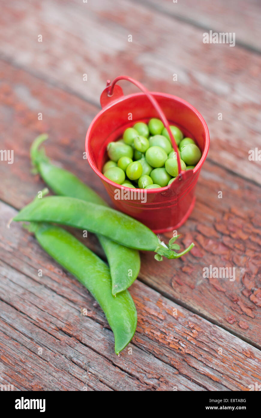 Peas in a bucket on a wooden background. Stock Photo