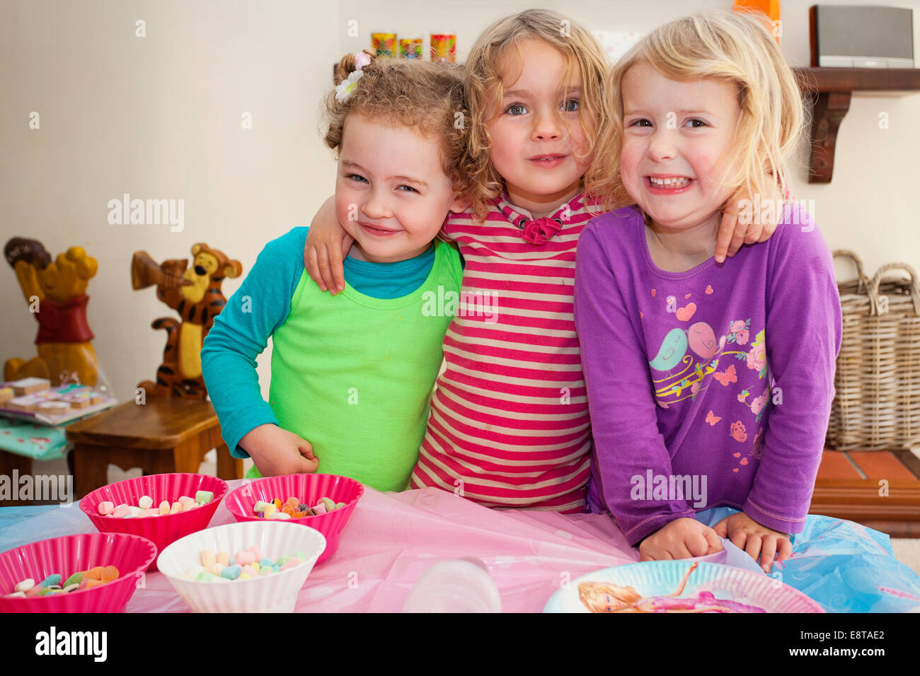 Three young girls pose for a birthday picture. Stock Photo