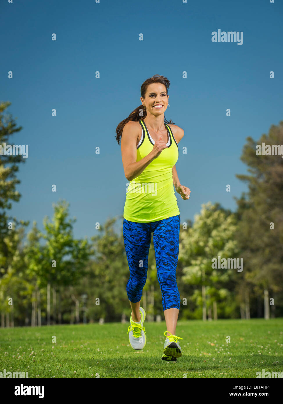 Mixed race woman jogging in park Stock Photo