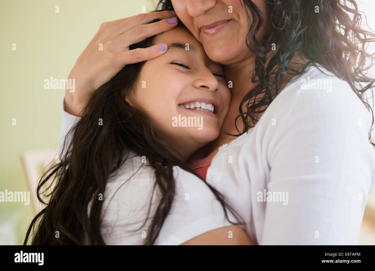 Hispanic mother and daughter hugging Stock Photo