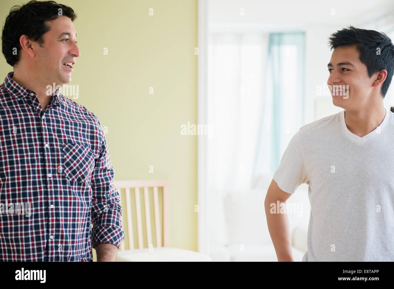 Hispanic father and son talking Stock Photo