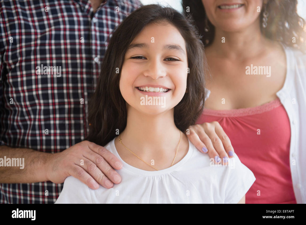 Hispanic girl smiling with parents Stock Photo
