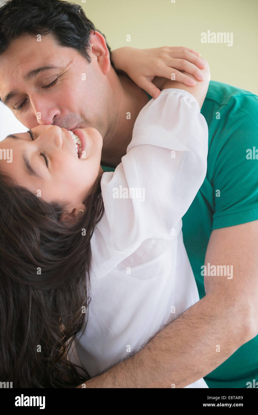 Hispanic father kissing daughter on cheek Stock Photo