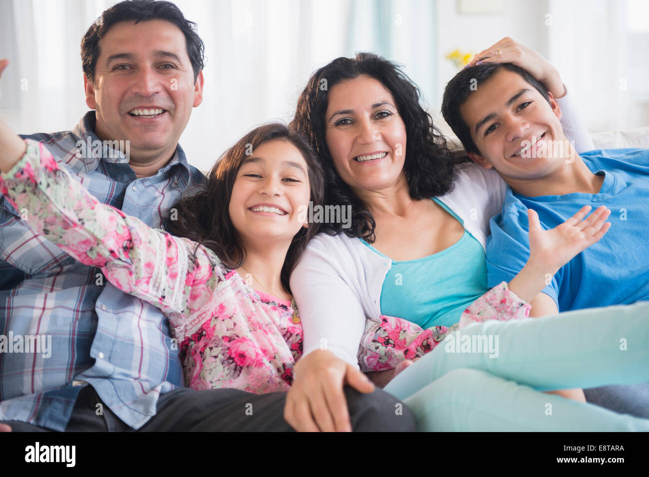 Hispanic family smiling together on sofa Stock Photo - Alamy