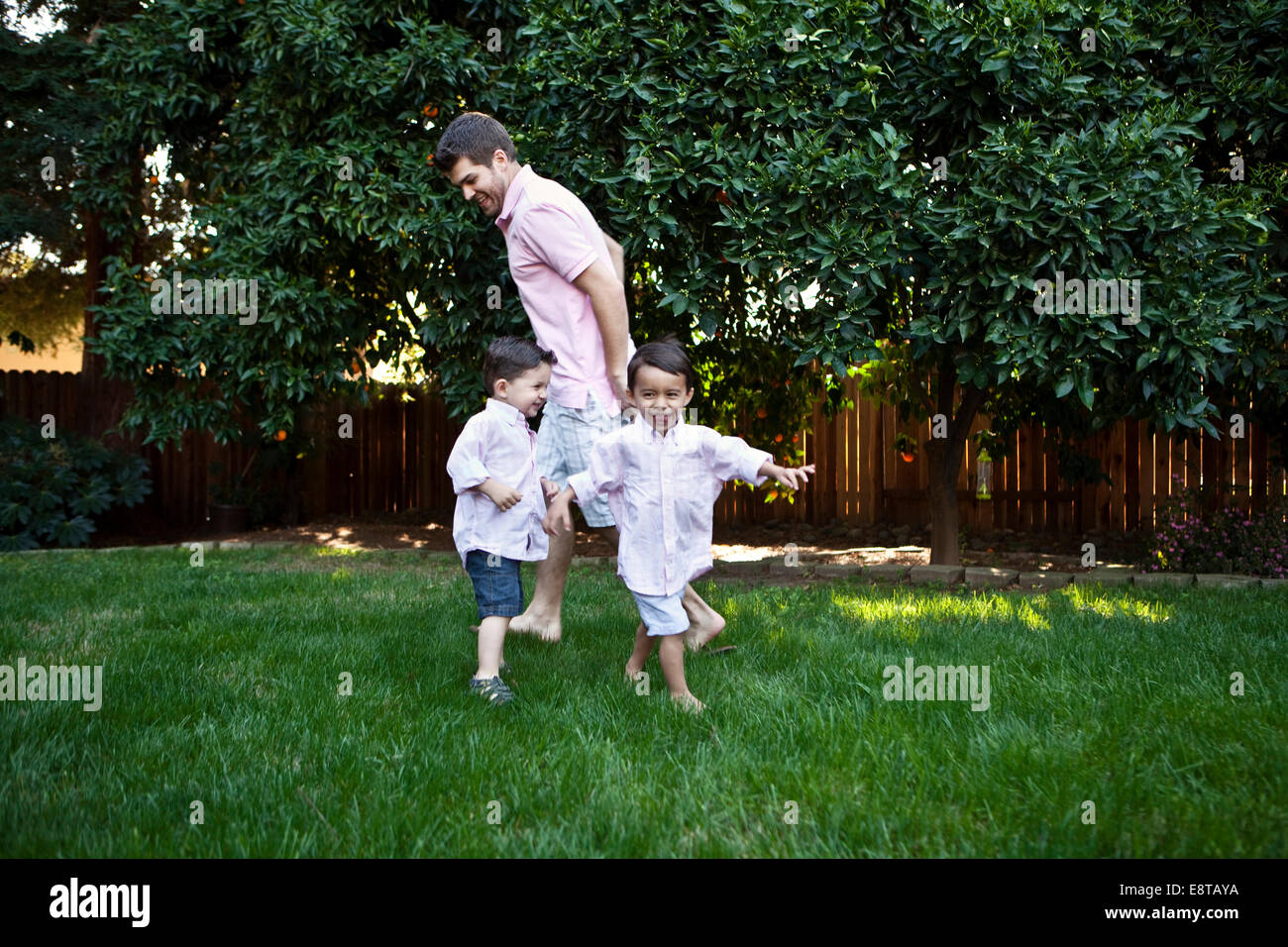 Caucasian father and sons playing in backyard Stock Photo