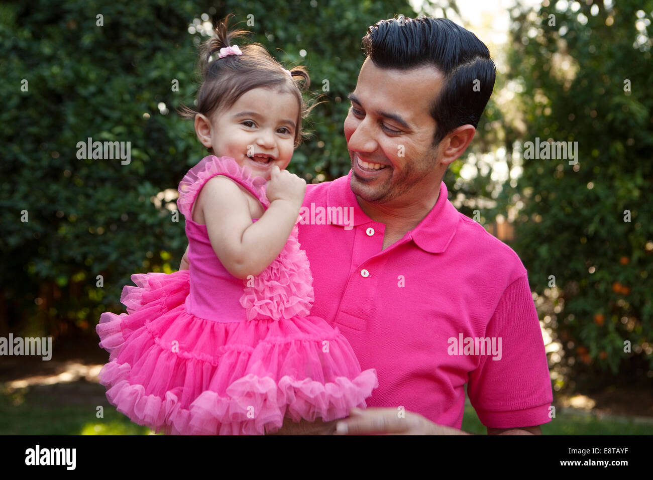 Father holding daughter in backyard Stock Photo
