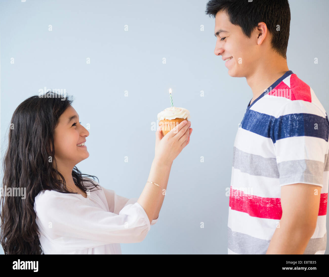 Hispanic brother and sister celebrating birthday with cupcake Stock Photo
