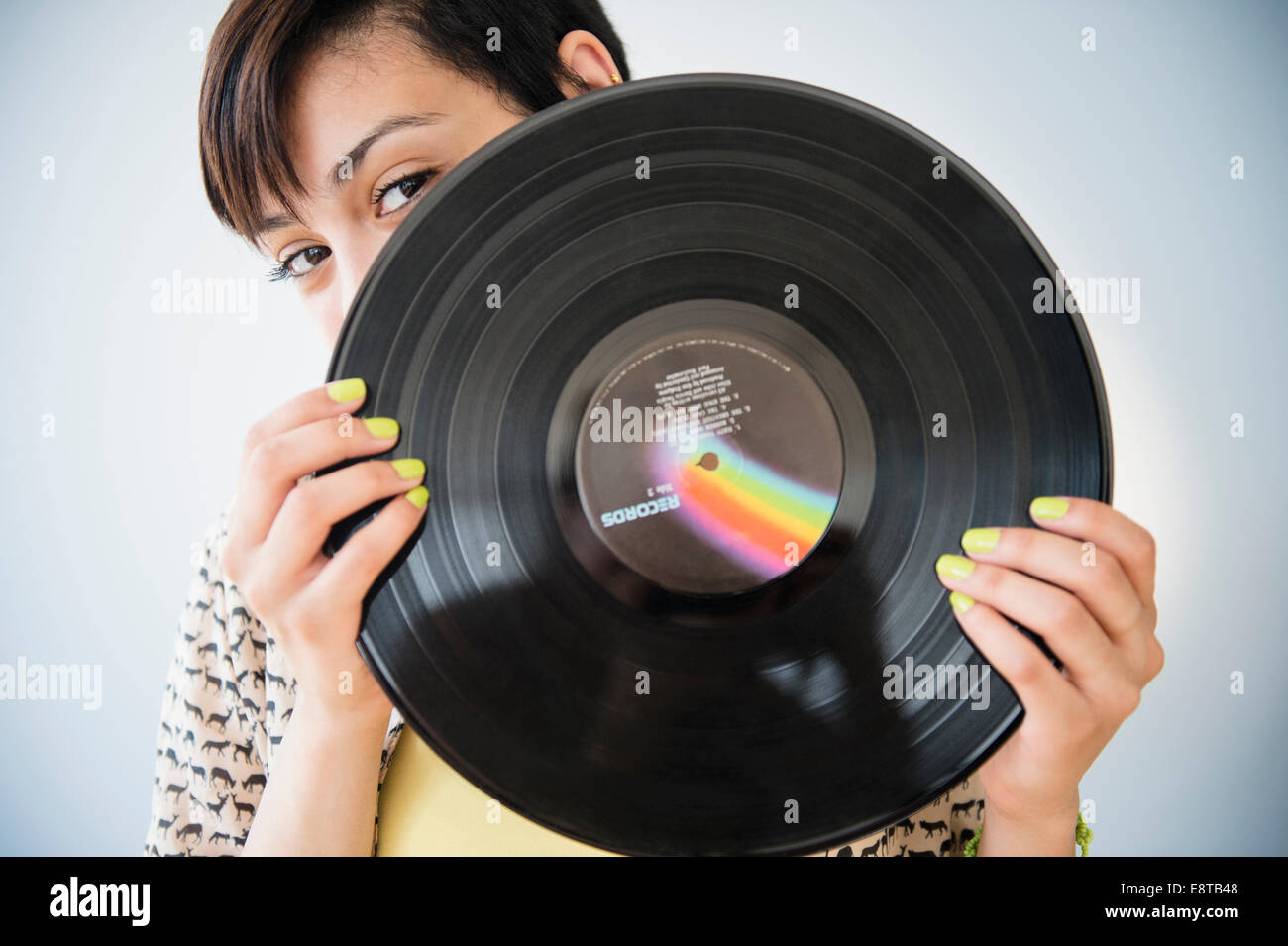 Mixed race woman holding vinyl record Stock Photo