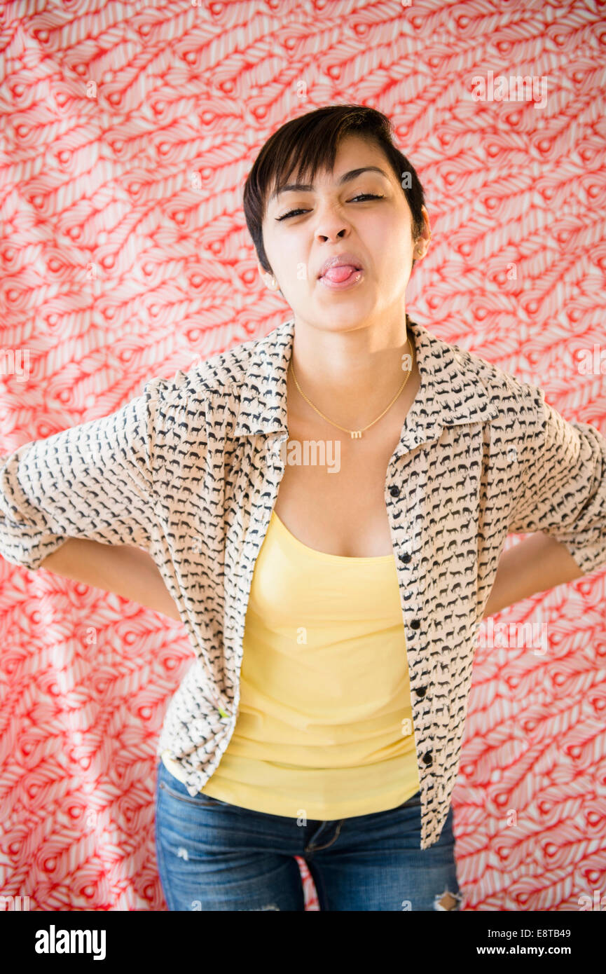 Mixed race woman sticking out tongue Stock Photo