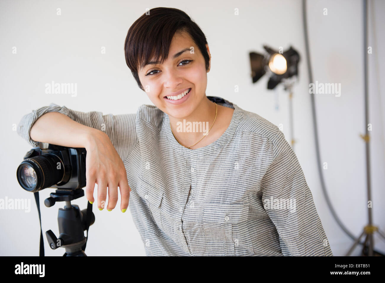 Mixed race photographer smiling in studio Stock Photo