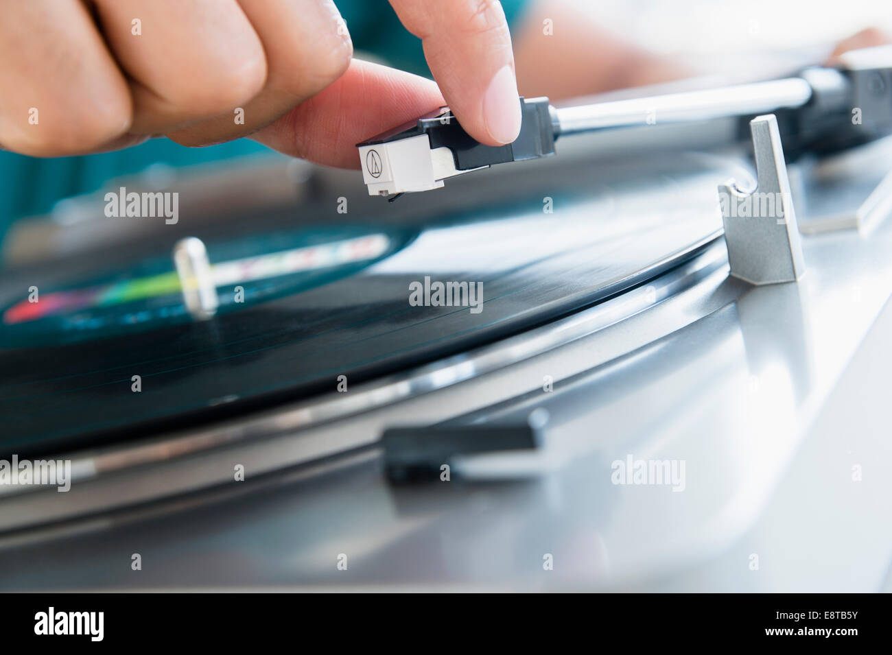 Close up of mixed race man playing vinyl record Stock Photo