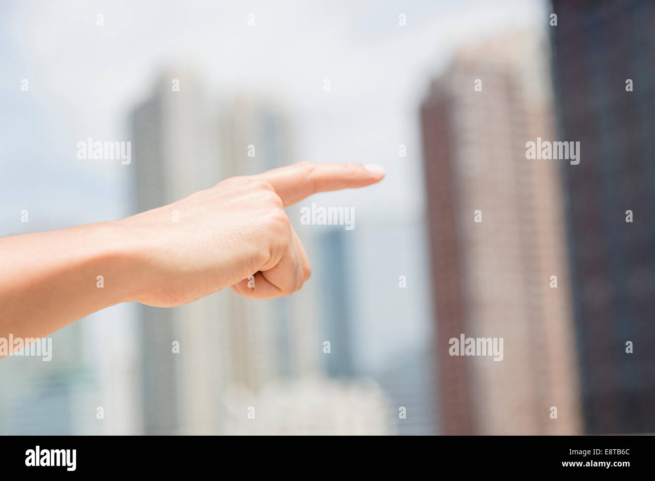 Close up of mixed race man pointing to city skyline Stock Photo