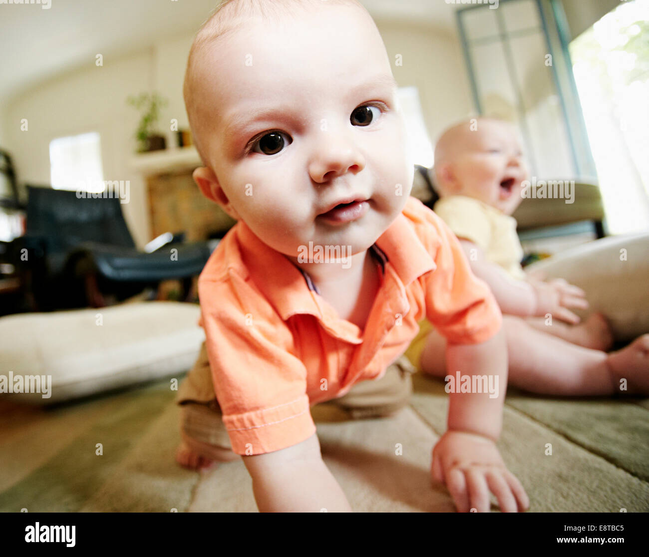 Caucasian baby crawling on living room floor Stock Photo