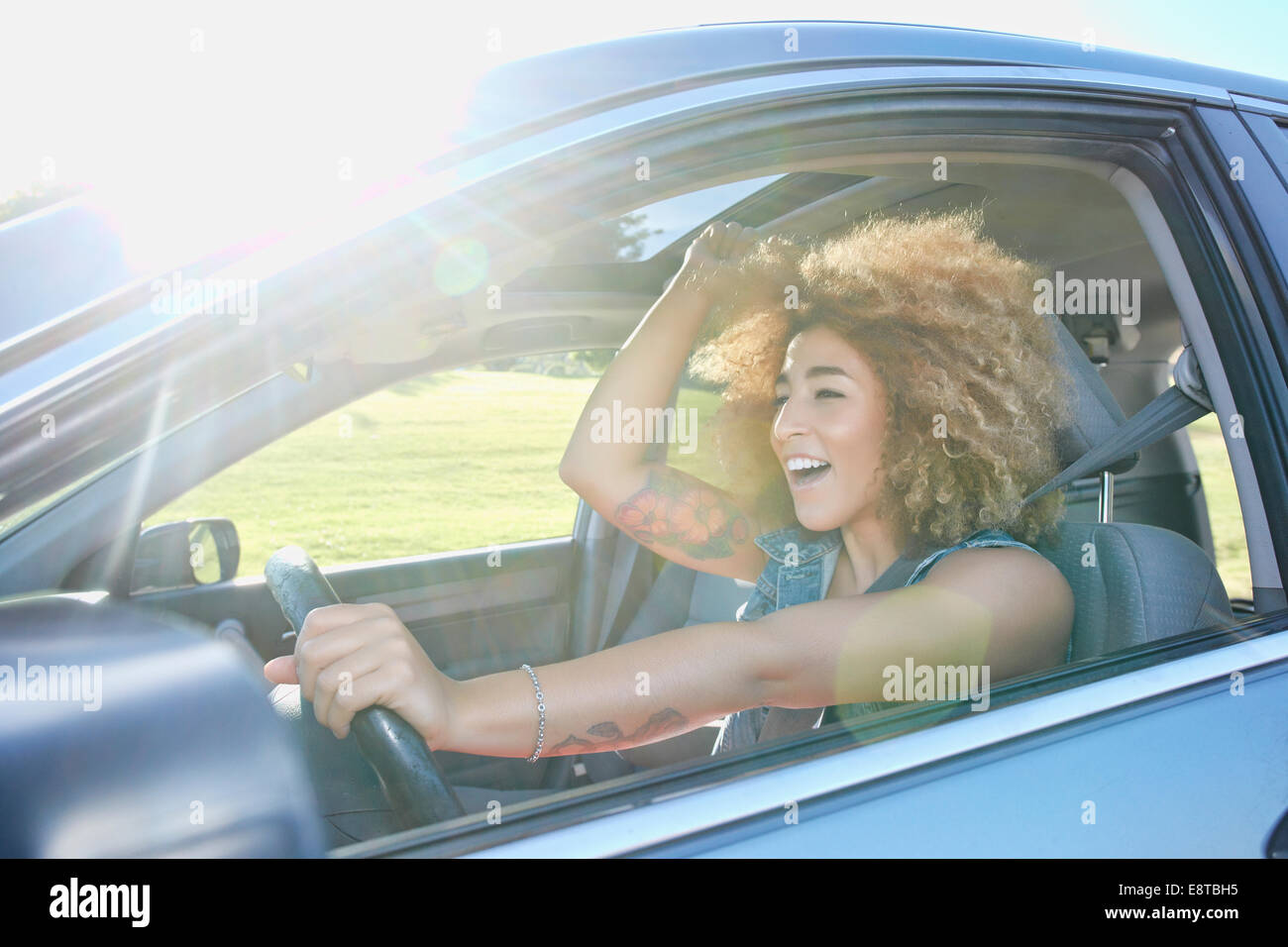 Hispanic woman cheering and driving car Stock Photo