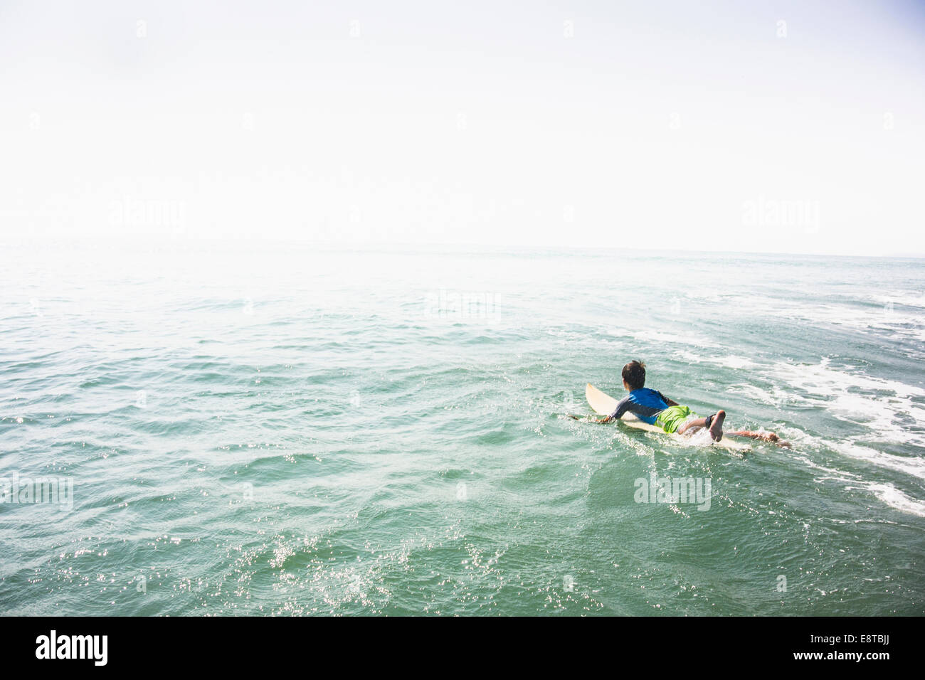 Caucasian boy surfing in ocean Stock Photo