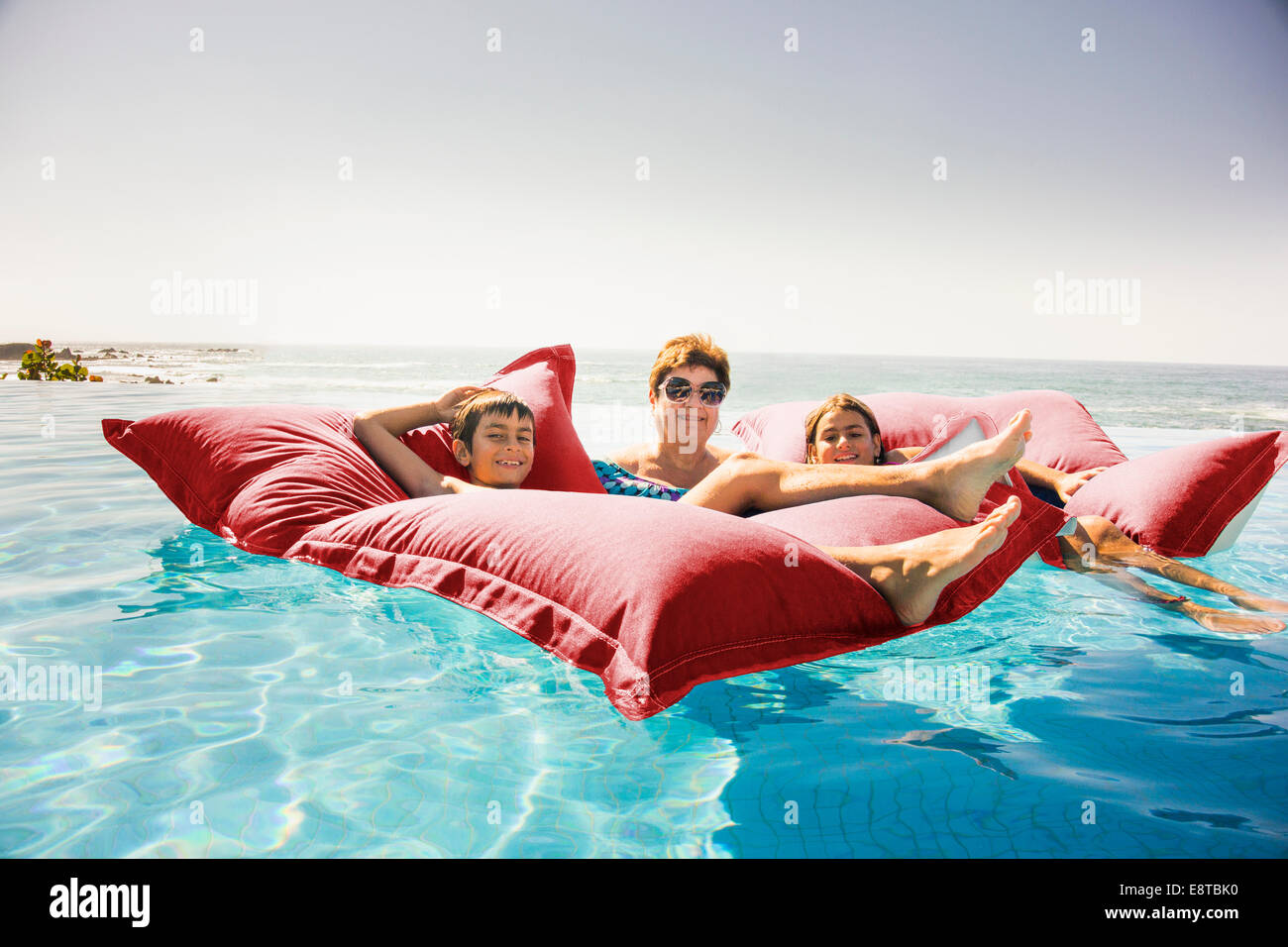 Grandmother and grandchildren relaxing on pool raft Stock Photo